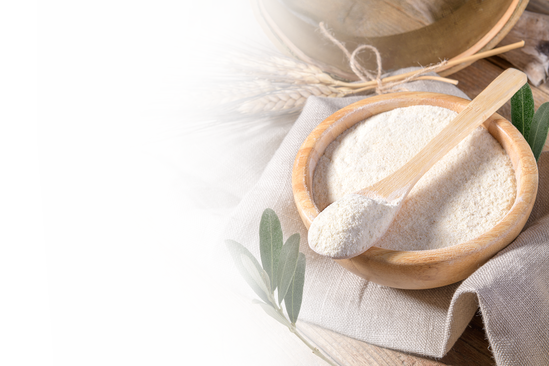 A bowl of nourishing flour with wheat and olive leaves